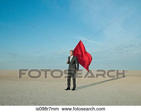 Businessman holding a red flag in a desert View Large Photo Image Picture - Businessman holding a red flag in a desert. Fotosearch
