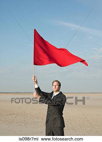 Businessman holding a red flag View Large Photo Image Stock Image - Businessman holding a red flag. Fotosearch
