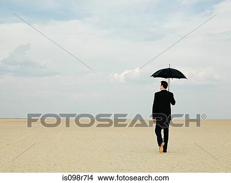 Businessman in the desert with an umbrella View Large Photo Image Picture - Businessman in the desert with an umbrella. Fotosearch