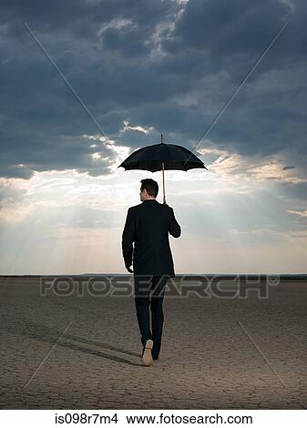 Businessman in the desert with an umbrella View Large Photo Image Picture - Businessman in the desert with an umbrella. Fotosearch