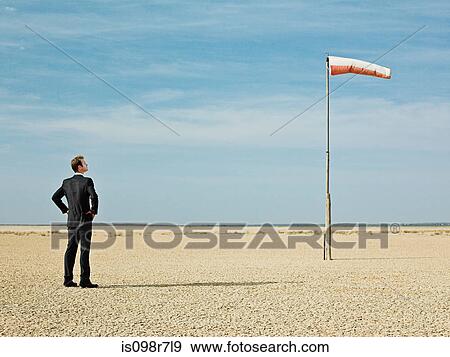 Businessman looking at a windsock View Large Photo Image Stock Photo - Businessman looking at a windsock. Fotosearch