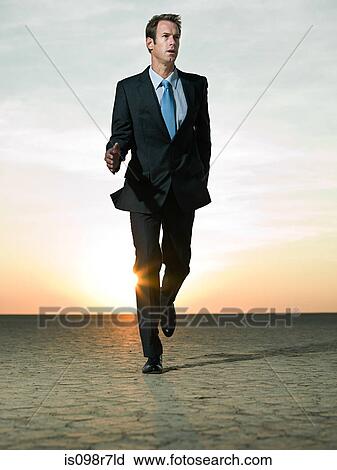 Businessman running in the desert View Large Photo Image Stock Image - Businessman running in the desert. Fotosearch