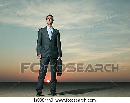 Businessman standing in the desert View Large Photo Image Stock Photo - Businessman standing in the desert. Fotosearch