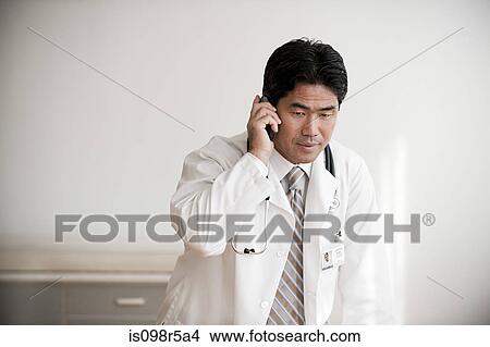 Picture - Doctor on cellphone. Fotosearch