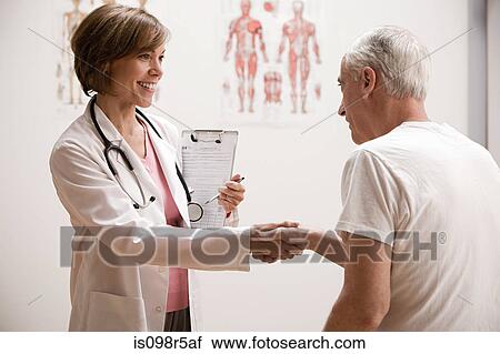 Stock Image - Doctor shaking hands with patient. Fotosearch