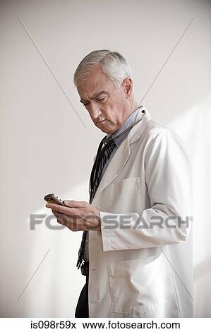 Doctor with cellphone View Large Photo Image Stock Photo - Doctor with cellphone. Fotosearch
