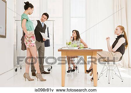 Fashion designers looking at clothing on model View Large Photo Image Stock Photo - Fashion designers looking at clothing on model. Fotosearch