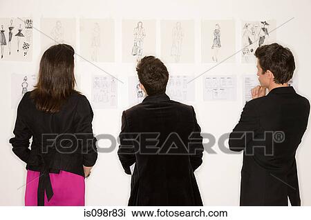 Stock Image - Fashion designers looking at designs. Fotosearch