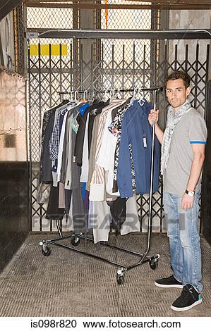 Man with rail of clothes View Large Photo Image Stock Image - Man with rail of clothes. Fotosearch