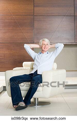Stock Photo - Middle aged man relaxing in modern armchair. Fotosearch