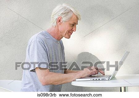 Middle aged man using laptop View Large Photo Image Stock Image - Middle aged man using laptop. Fotosearch