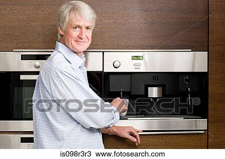 Middle aged man waiting for coffee from coffee machine View Large Photo Image Stock Image - Middle aged man waiting for coffee from coffee machine. Fotosearch
