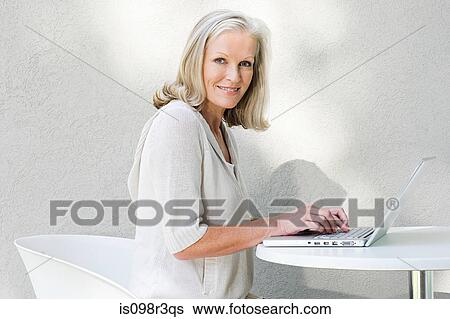Middle aged woman using laptop View Large Photo Image Stock Photograph - Middle aged woman using laptop. Fotosearch