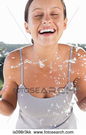 Smiling young woman splashing water on face View Large Photo Image Stock Image - Smiling young woman splashing water on face. Fotosearch