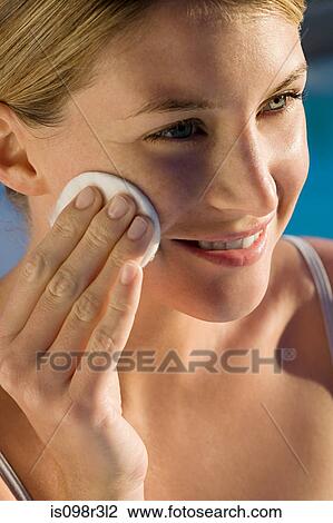 Young woman cleaning face with cotton pad View Large Photo Image Stock Image - Young woman cleaning face with cotton pad. Fotosearch