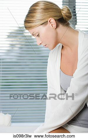 Young woman sitting on edge of bathtub View Large Photo Image Stock Photo - Young woman sitting on edge of bathtub. Fotosearch
