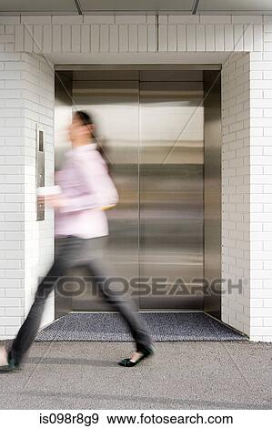 Blurred woman walking past elevator View Large Photo Image Stock Photo - Blurred woman walking past elevator. Fotosearch