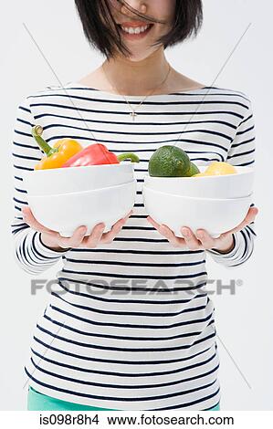 Picture - Woman holding bowls of vegetables. Fotosearch