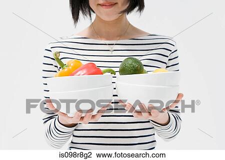 Woman holding bowls of vegetables View Large Photo Image Stock Image - Woman holding bowls of vegetables. Fotosearch