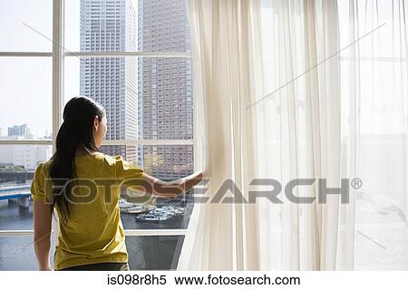 Stock Photography - Woman lookinng through a window. Fotosearch