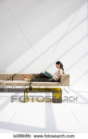 Woman reading on a sofa View Large Photo Image Stock Image - Woman reading on a sofa. Fotosearch