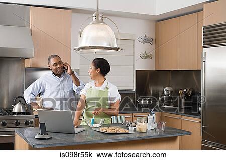 Couple in kitchen with laptop and cellphone View Large Photo Image Stock Image - Couple in kitchen with laptop and cellphone. Fotosearch