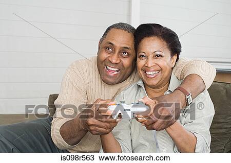 Mature couple playing video game View Large Photo Image Stock Image - Mature couple playing video game. Fotosearch