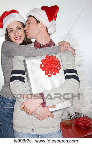 Couple in santa hats kissing View Large Photo Image Stock Image - Couple in santa hats kissing. Fotosearch