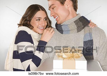 Happy young couple holding a gift View Large Photo Image Stock Photo - Happy young couple holding a gift. Fotosearch