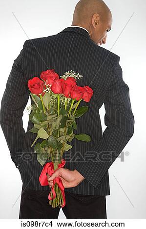 Man with a bunch of roses behind his back View Large Photo Image Picture - Man with a bunch of roses behind his back. Fotosearch
