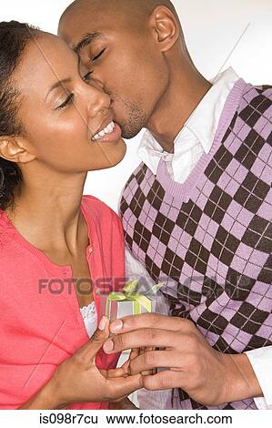 Romantic couple holding a gift View Large Photo Image Stock Photograph - Romantic couple holding a gift. Fotosearch