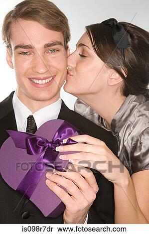 Stock Photography - Romantic couple holding a gift. Fotosearch