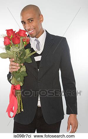 Smiling man holding a bunch of roses View Large Photo Image Stock Image - Smiling man holding a bunch of roses. Fotosearch