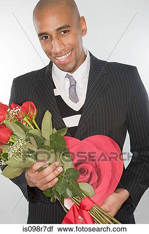 Smiling man holding a bunch of roses View Large Photo Image Stock Image - Smiling man holding a bunch of roses. Fotosearch