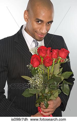 Smiling man holding a bunch of roses View Large Photo Image Stock Image - Smiling man holding a bunch of roses. Fotosearch