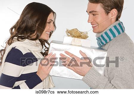 Stock Photograph - Young couple holding gifts. Fotosearch
