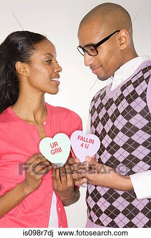 Young couple holding heart shapes View Large Photo Image Stock Image - Young couple holding heart shapes. Fotosearch