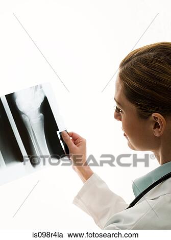 Stock Image - Female doctors looking at x-rays. Fotosearch