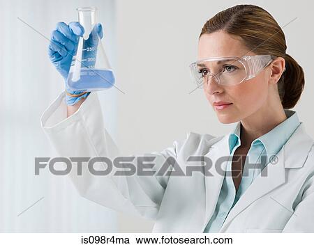 Stock Image - Female scientist holding a flask. Fotosearch