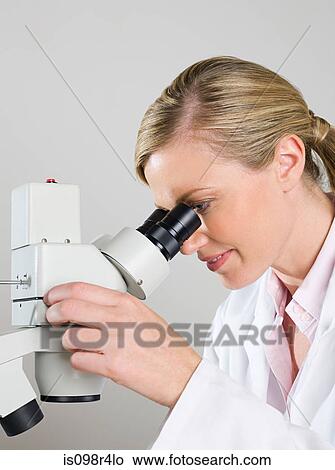 Female scientist using a microscope View Large Photo Image Picture - Female scientist using a microscope. Fotosearch