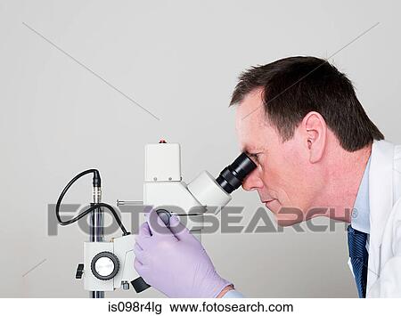 Stock Image - Male scientist using a microscope. Fotosearch