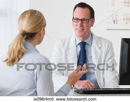 Stock Photography - Woman talking to a doctor. Fotosearch