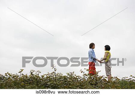Young couple holding hands outdoors View Large Photo Image Stock Photograph - Young couple holding hands outdoors. Fotosearch