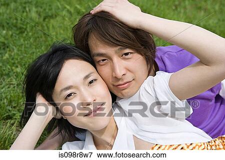 Young couple lying on grass View Large Photo Image Stock Photo - Young couple lying on grass. Fotosearch