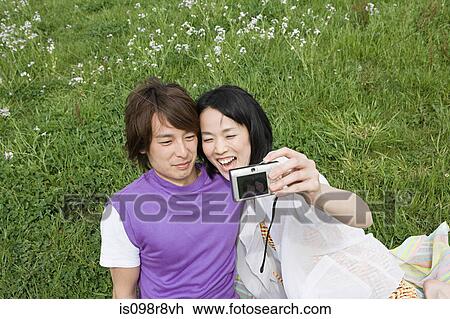 Young couple on field with camera View Large Photo Image Stock Image - Young couple on field with camera. Fotosearch