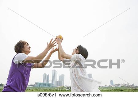 Stock Image - Young couple playing ball game. Fotosearch