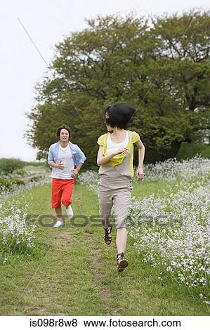 Stock Photo - Young couple running through field. Fotosearch