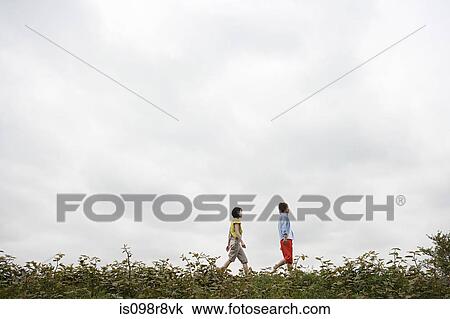 Stock Image - Young couple walking outdoors. Fotosearch
