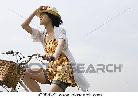 Stock Image - Young woman cycling. Fotosearch