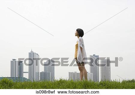 Young woman in front of city skyline View Large Photo Image Stock Image - Young woman in front of city skyline. Fotosearch